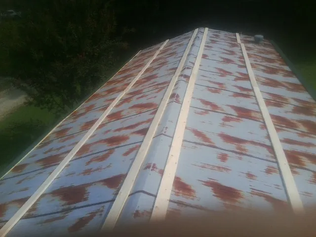 Rusted metal roof panels with new wood purlins before replacement — Storm Damage Roof Repair in Halls by Roofing Brothers