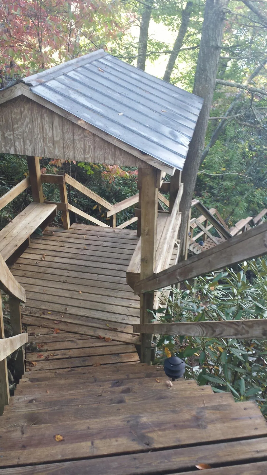 Metal roofed shelter over wooden steps on a wooded walkway — Skylight Repair & Installation work by our crew in Halls