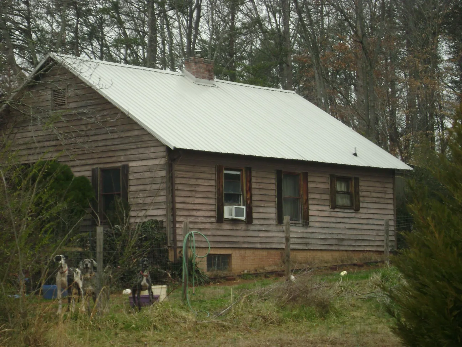 White metal roof on an old wood sided farmhouse, from a Metal Roof Installation job in Halls